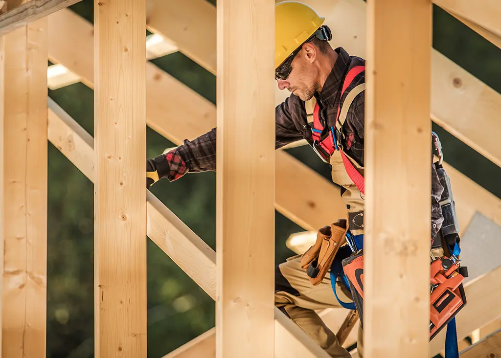 carpenter working on a framed home rafters
